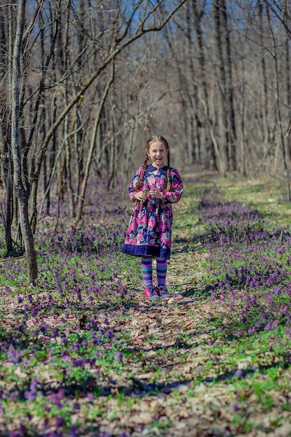 Portret van een mooi klein meisje met corydalis bloemen