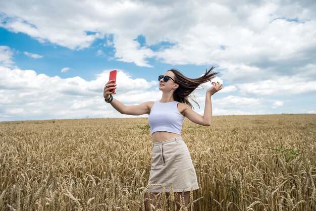 Portret van een mooi meisje dat zich voordeed op de achtergrond van een landbouwveld zomertijd