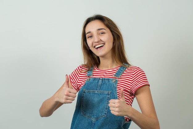 Portret van een mooi meisje in een gestreept T-shirt kijkt opzij met peinzende uitdrukking en overweegt een plan voor verdere actie