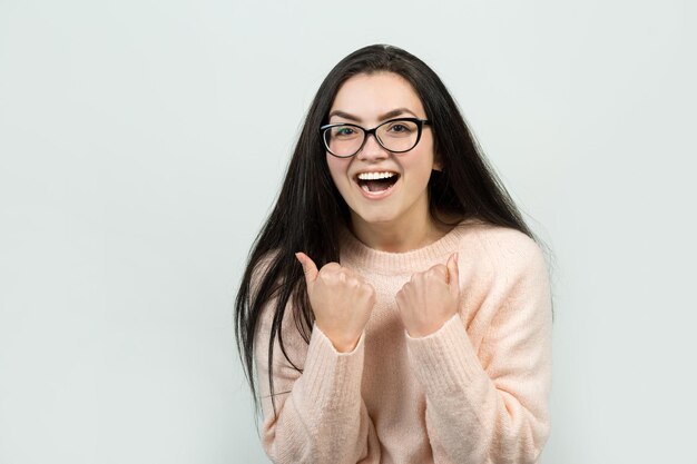 Portret van een mooi meisje in een roze trui kijkt opzij met peinzende uitdrukking en overweegt een plan voor verdere actie