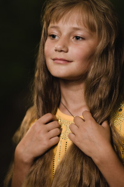 Portret van een mooi meisje met lang blond haar in een bos