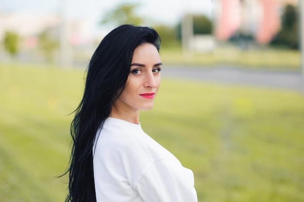 Portret van een mooi meisje met zwarte haren op straat