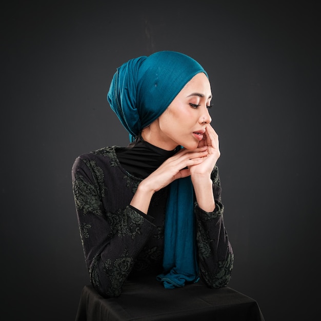 Portret van een mooi moslim vrouwelijk model dat moderne vrijetijdskleding draagt met hijab geïsoleerd op donker