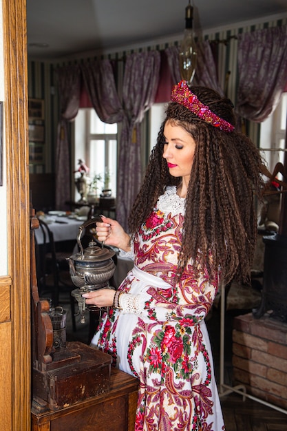 Portret van een mooi Russisch meisje in een kokoshnik en traditionele kleding