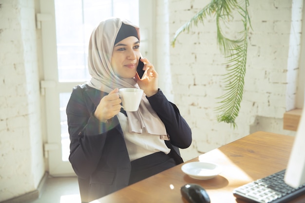 Portret van een mooie Arabische zakenvrouw die hijab draagt tijdens het werken