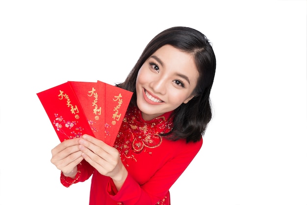 Portret van een mooie Aziatische vrouw op traditioneel festivalkostuum Ao Dai met rode zak - geluksgeld Tet vakantie. Nieuw maanjaar.