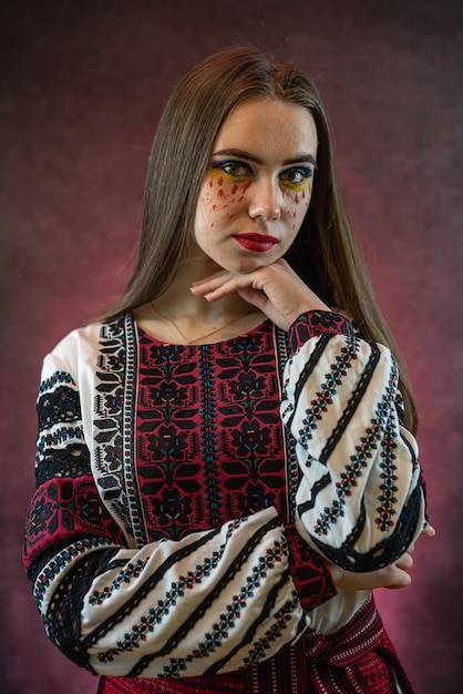 Portret van een mooie blanke Oekraïense jonge vrouw draagt rode geborduurde jurk vyshyvanka op donkere achtergrond studio shoot Oekraïense nationale kleding