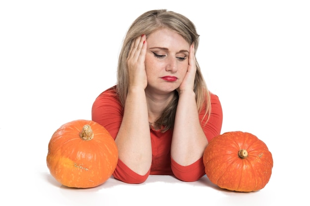 Portret van een mooie blonde vrouw van middelbare leeftijd met pompoen klaar voor halloween-vieringsmodel voor ansichtkaart en uitnodiging of advertentie