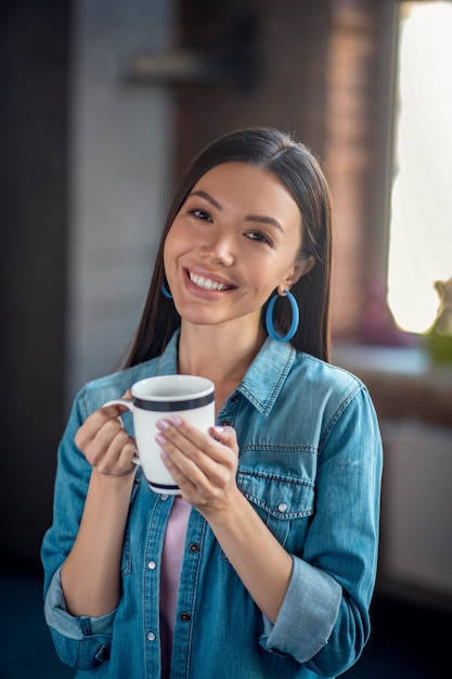 Portret van een mooie gelukkige vrouw met een kopje thee