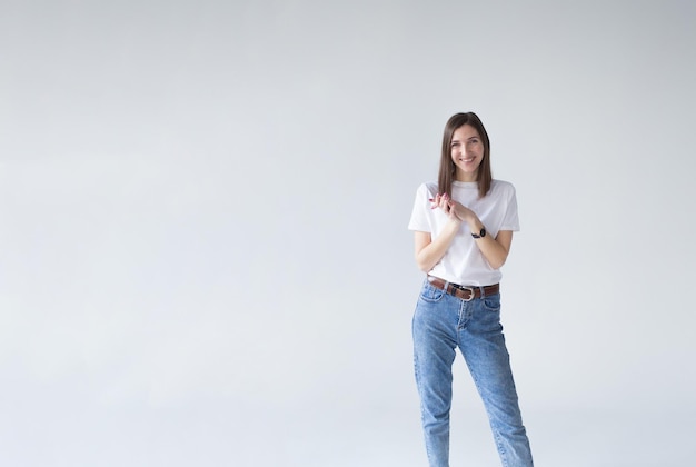 Portret van een mooie glimlachende zakenvrouw die met haar handen gevouwen staat en naar haar kijkt