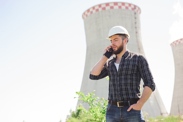 Portret van een mooie ingenieur op het werk met de telefoon