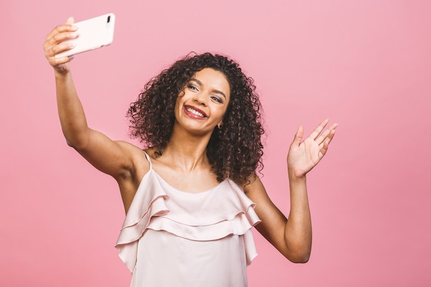 Portret van een mooie jonge afro-Amerikaanse vrouw in jurk terwijl staande en het nemen van een selfie