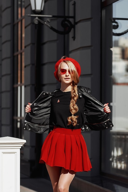 Portret van een mooie jonge blonde vrouw in een stijlvolle zwarte outfit die lacht