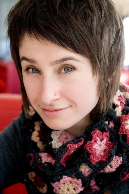Portret van een mooie jonge brunette in een gebreide sjaal