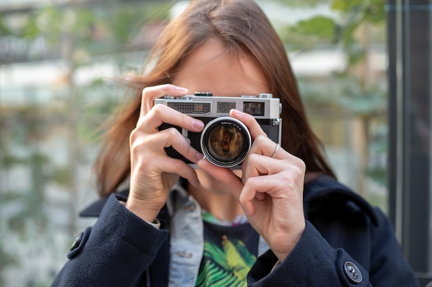 Portret van een mooie jonge toerist die foto's maakt met een vintage retro camera. Street Style. levensstijl