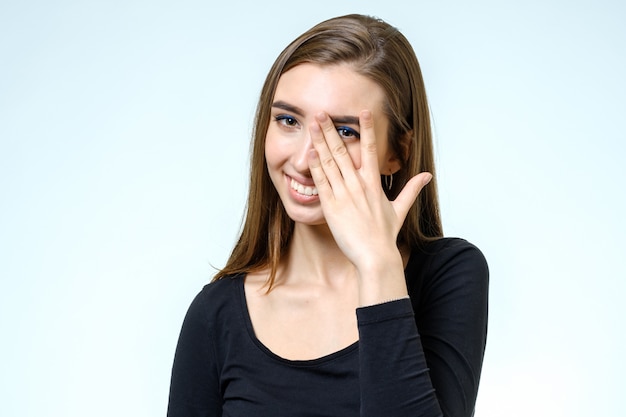 Portret van een mooie jonge vrouw die de camera en het glimlachen bekijkt