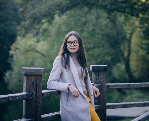 Portret van een mooie jonge vrouw die een jas buitenshuis draagt