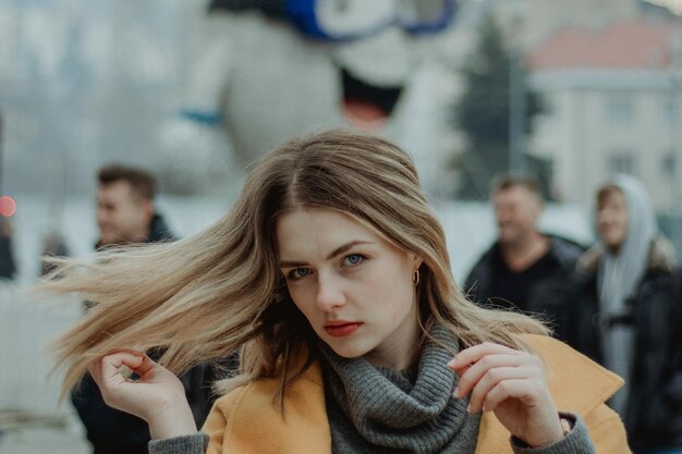 Portret van een mooie jonge vrouw die haar in de stad gooit