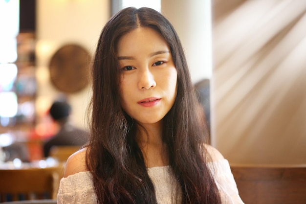 Portret van een mooie jonge vrouw die in een restaurant zit
