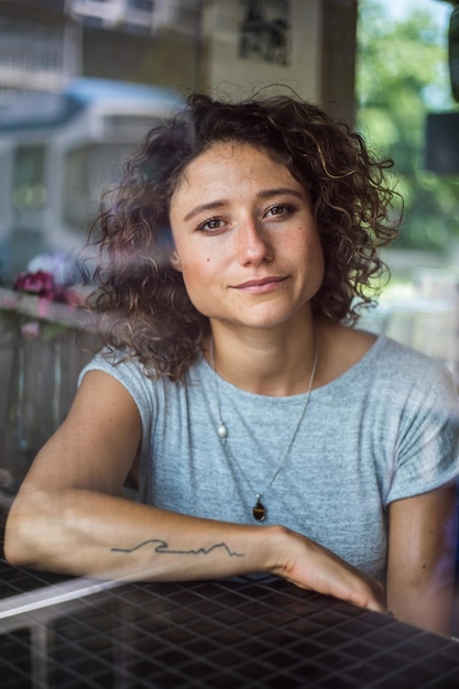 Portret van een mooie jonge vrouw die op tafel zit