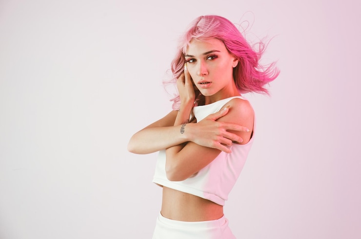 Foto portret van een mooie jonge vrouw die tegen een witte achtergrond staat