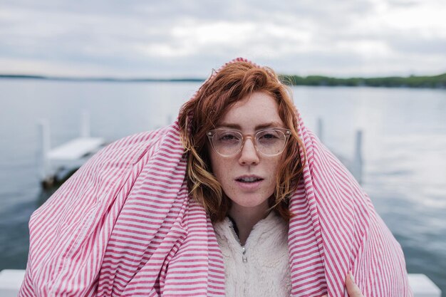 Foto portret van een mooie jonge vrouw die tegen het meer staat