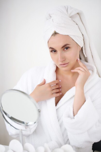 Foto portret van een mooie jonge vrouw in een badjas na het douchen