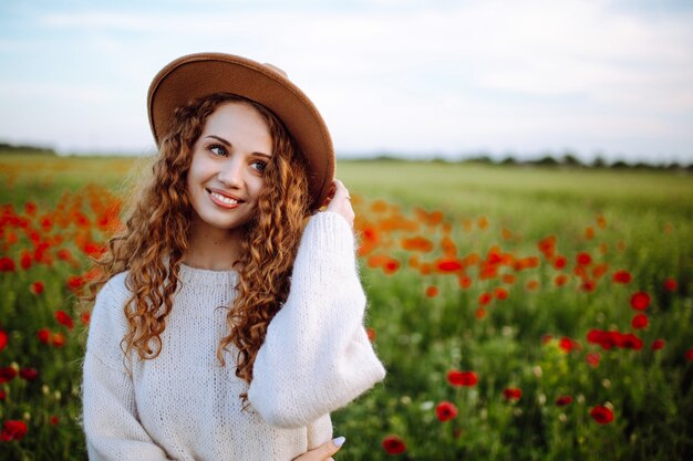 Portret van een mooie jonge vrouw in een papaverveld