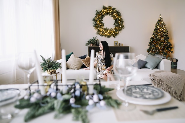 Portret van een mooie jonge vrouw in feestelijk kerst- en nieuwjaarsinterieur