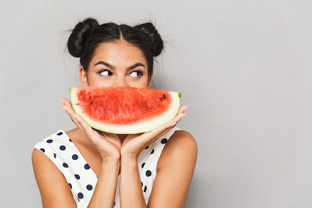 Portret van een mooie jonge vrouw in geïsoleerde zomerjurk, met watermeloenplak