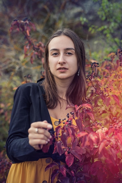 Portret van een mooie jonge vrouw in kleurrijk herfstbos