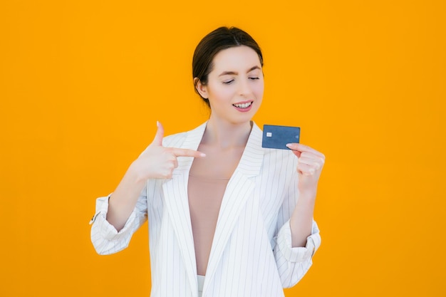 Portret van een mooie jonge vrouw met creditcard op haar gezicht