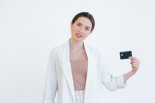 Portret van een mooie jonge vrouw met creditcard op haar gezicht