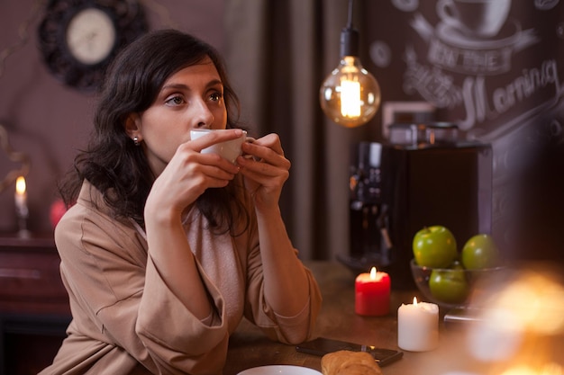 Portret van een mooie jonge vrouw met een kopje koffie aan de bar in een coffeeshop. Mooie vrouw ontspannen in een coffeeshop met een kopje koffie.