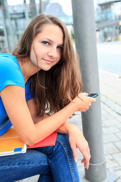 Foto portret van een mooie jonge vrouw met een smartphone