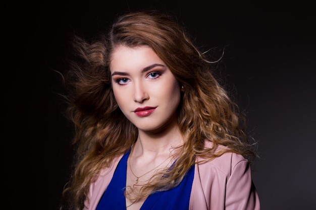 Portret van een mooie jonge vrouw op een zwarte achtergrond