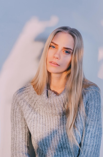 Portret van een mooie jonge vrouw tegen de muur