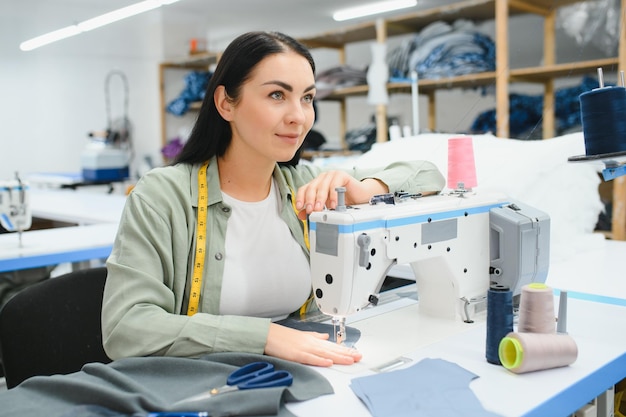 Portret van een mooie naaister die een meetlint draagt en in een textielfabriek werkt