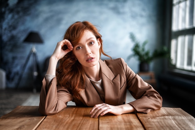 Portret van een mooie secretaressezitting bij haar bureau