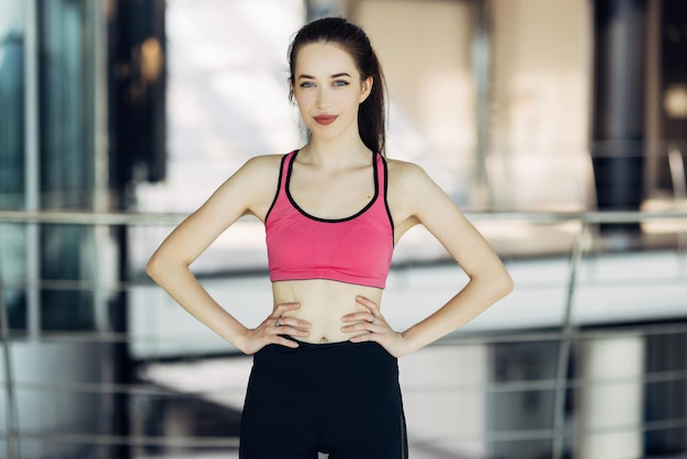 Portret van een mooie sportieve vrouw die in de sportschool staat