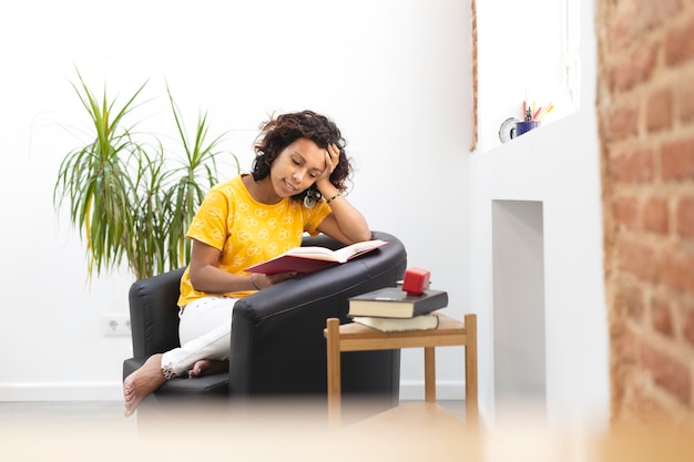 Portret van een mooie vrouw die thuis een boek leest. Ruimte voor tekst.