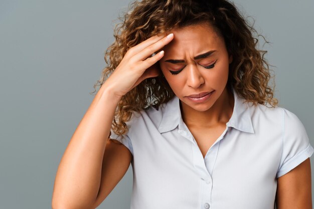 Portret van een mooie vrouw met bleek haar in een wit shortsleeve hemd met een ernstige hoofdpijn