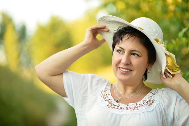 Portret van een mooie vrouw met een hoed die buitenshuis poseert