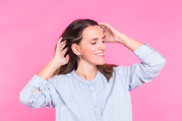 Portret van een mooie vrouw met lang bruin haar die blauwe katoenen blouse draagt