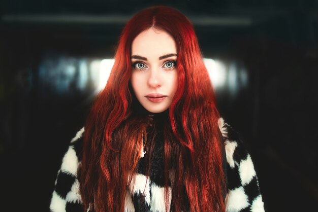Portret van een mooie vrouw met rood haar die in de ondergrondse passage staat standing