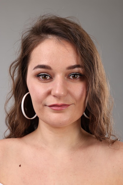 Portret van een mooie vrouw op een lichtgrijze achtergrond