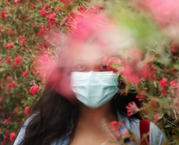 Portret van een mooie vrouw tegen rode bloeiende planten