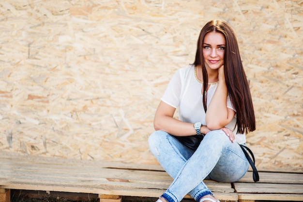 Portret van een mooie vrouw zittend op houten planken