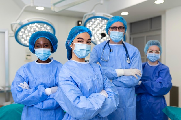 Portret van een multicultureel medisch team dat in de operatiekamer staat Portret van succesvolle medische werkers in chirurgisch uniform in de operatiekamer klaar voor de volgende operatie