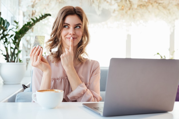 Portret van een nadenkende jonge creditcard van de vrouwenholding goldern